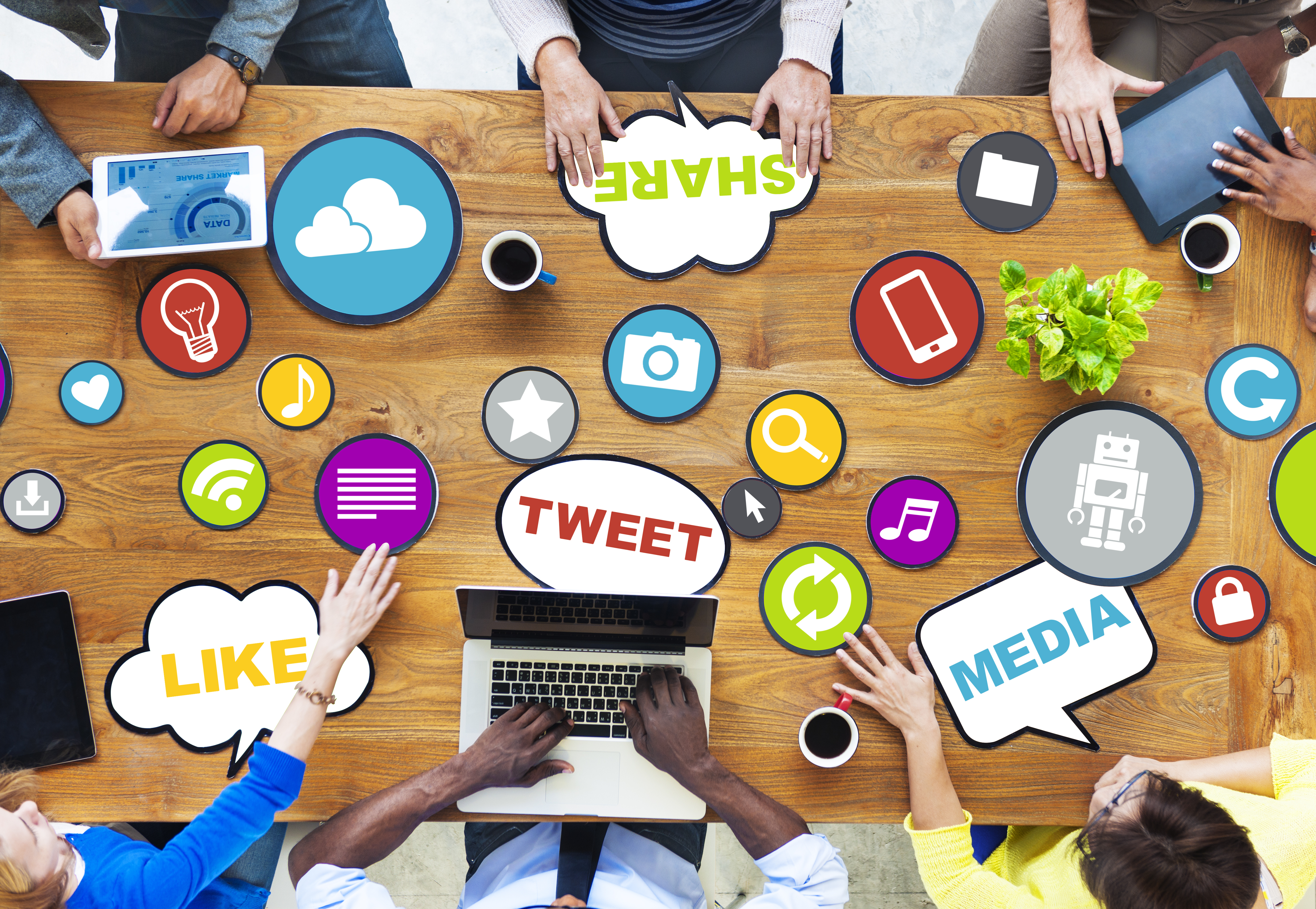 table covered in social media logos with people surrounding